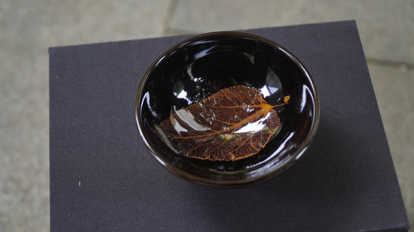 Ceramic cup with a lifelike leaf at the bottom