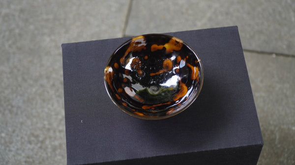 Ceramic cup with a visual reminiscent of fiery lava flows against a night sky