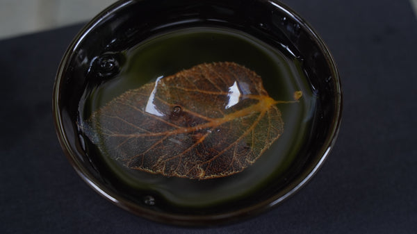 Ceramic cup with a lifelike leaf at the bottom